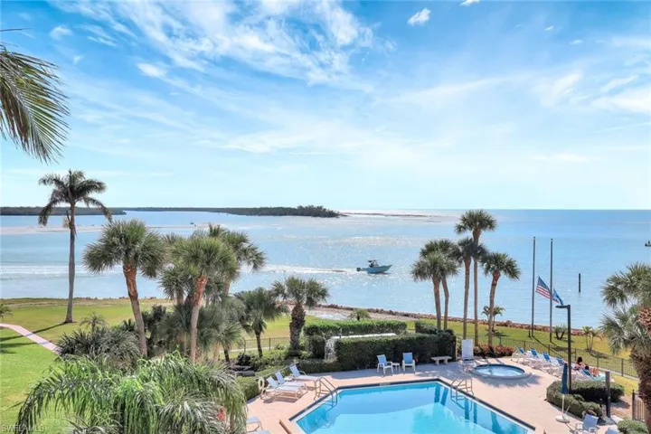 View of swimming pool featuring a community hot tub, a patio, and a water view