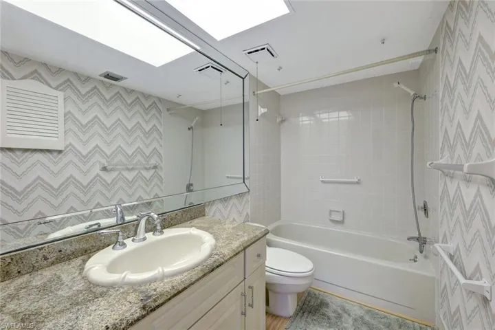 Full bathroom featuring toilet, tiled shower / bath, and vanity