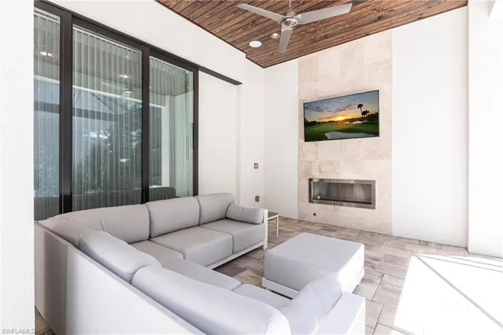 Living room featuring a tile fireplace, wooden ceiling, and ceiling fan
