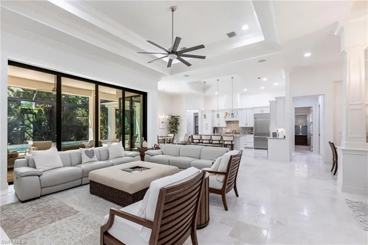 Living area with visible vents, crown molding, ceiling fan, recessed lighting, and a raised ceiling