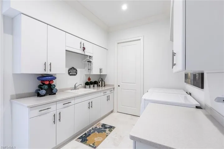Washroom featuring washer and clothes dryer, a sink, recessed lighting, crown molding, and laundry area