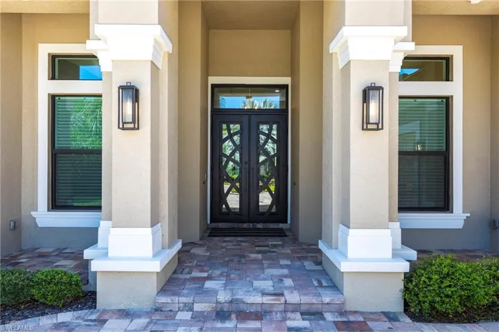 Doorway to property featuring french doors and stucco siding