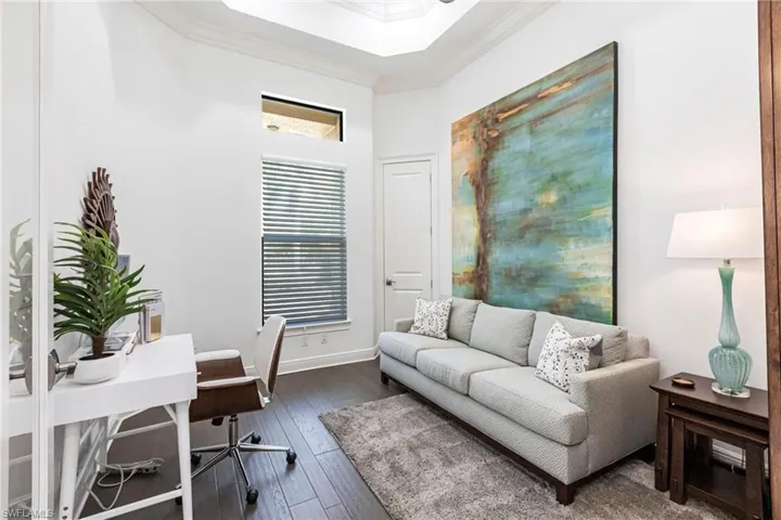 Office area featuring crown molding, baseboards, and dark wood-style flooring