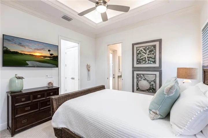 Bedroom featuring visible vents, light carpet, connected bathroom, and crown molding