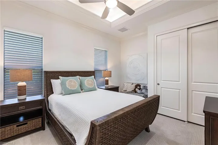 Bedroom with visible vents, ceiling fan, a closet, light carpet, and crown molding