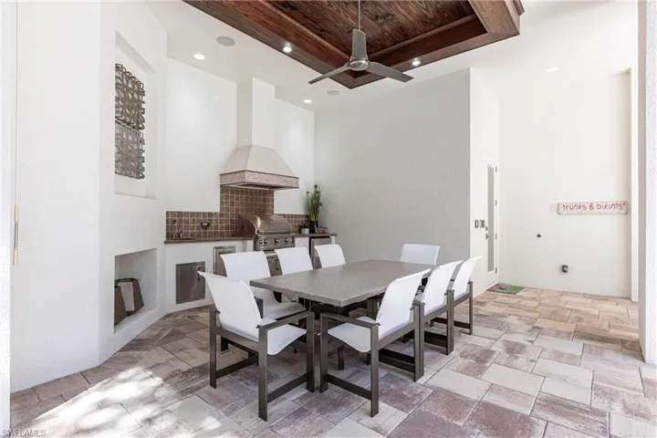 Dining room with a tray ceiling, recessed lighting, ceiling fan, wood ceiling, and stone finish flooring