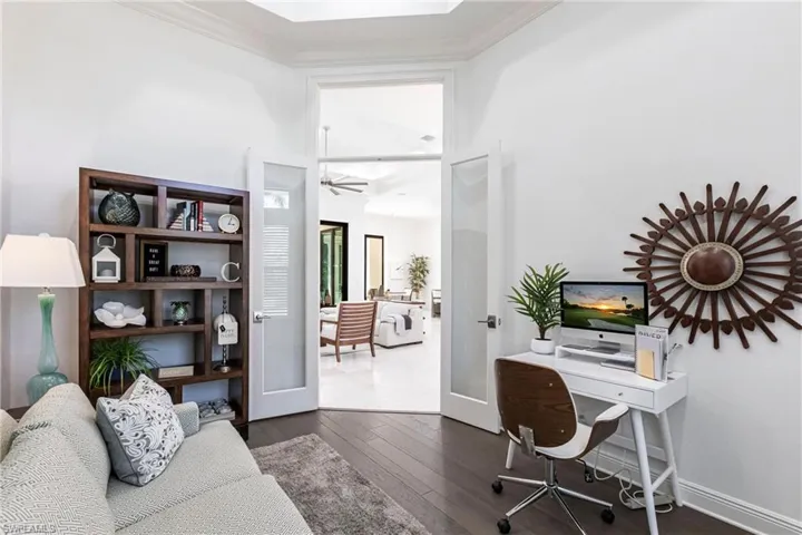 Office area featuring ornamental molding, baseboards, a ceiling fan, and hardwood / wood-style floors