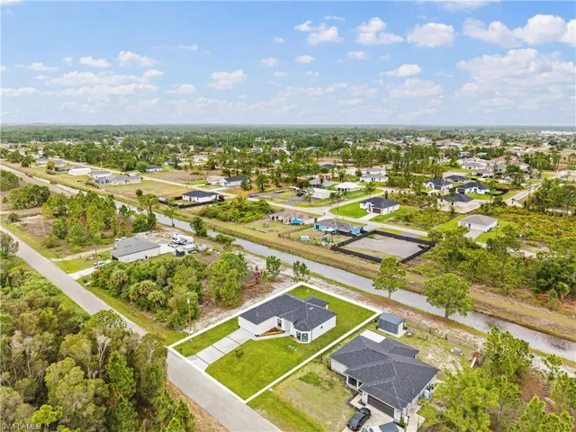 Aerial perspective of suburban area featuring a nearby body of water