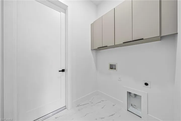 Laundry room featuring electric dryer hookup, hookup for a washing machine, cabinet space, and light marble finish flooring