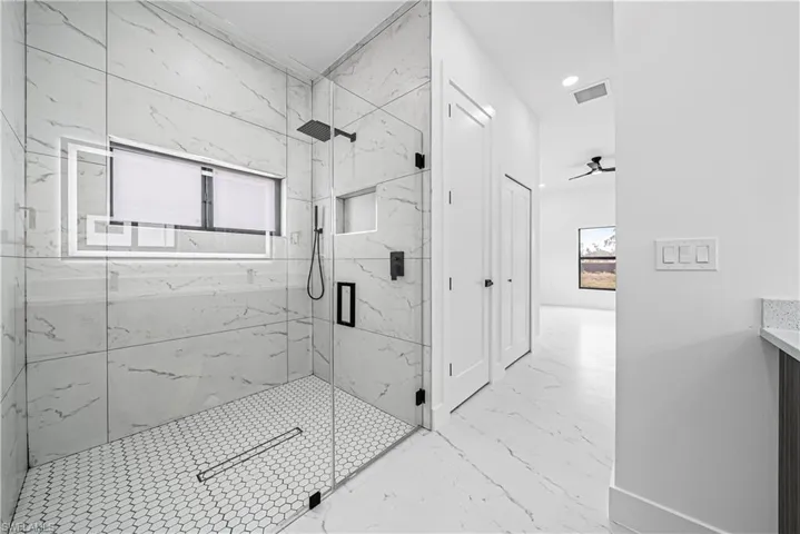 Bathroom with a marble finish shower, vanity, recessed lighting, a ceiling fan, and light marble finish flooring