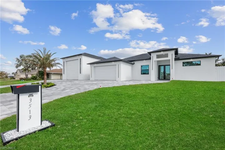 View of front of property featuring a garage and a front yard
