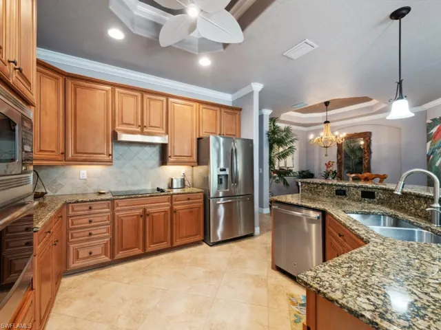 Kitchen with visible vents, ornamental molding, brown cabinets, a sink, and stainless steel appliances