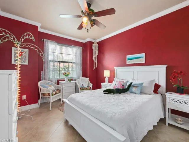 Bedroom with crown molding, a ceiling fan, baseboards, and light tile patterned floors
