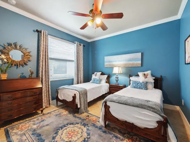 Bedroom featuring baseboards, ornamental molding, and a ceiling fan