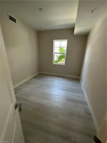 Spare room featuring light wood-type flooring and baseboards