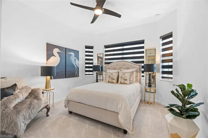 Bedroom with carpet, multiple windows, and ceiling fan