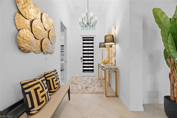 Entrance foyer with a notable chandelier and light tile floors
