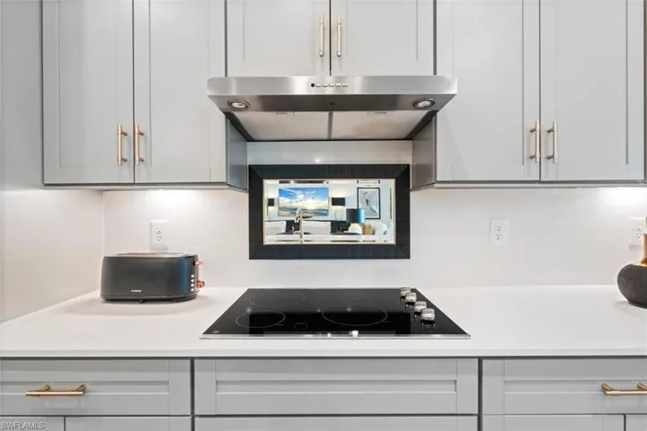 Kitchen with gray cabinets and black electric cooktop