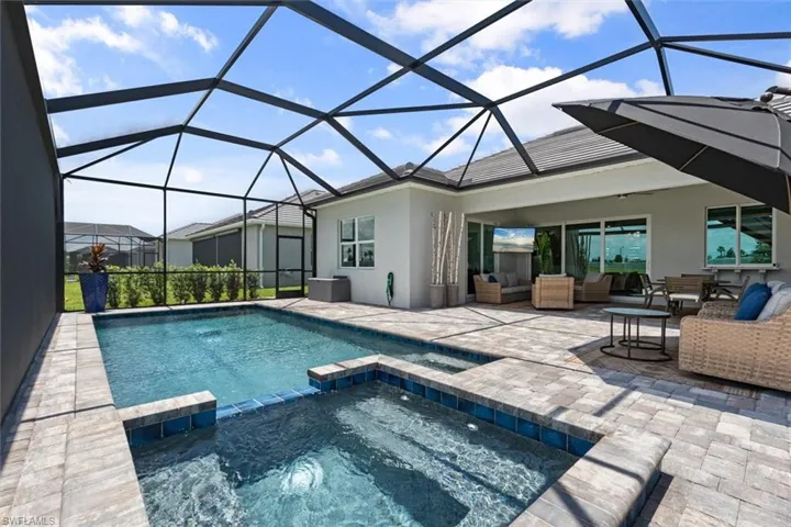View of pool featuring an outdoor hangout area, a lanai, an in ground hot tub, and a patio