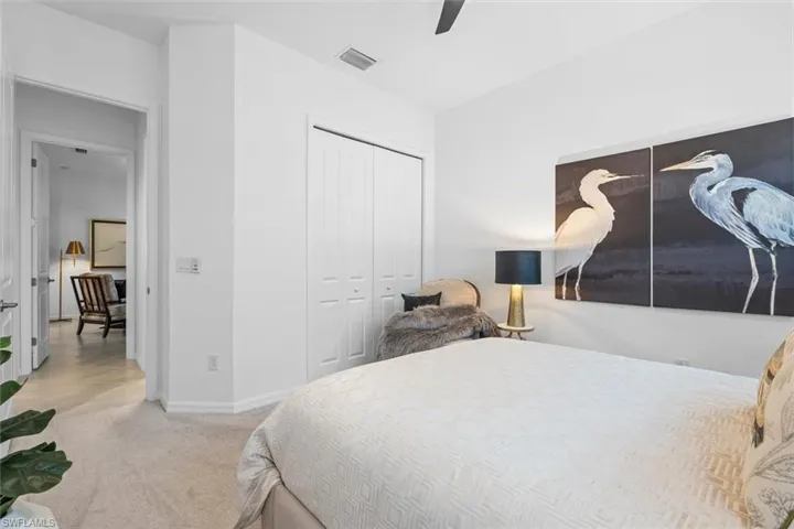 Carpeted bedroom featuring ceiling fan and a closet