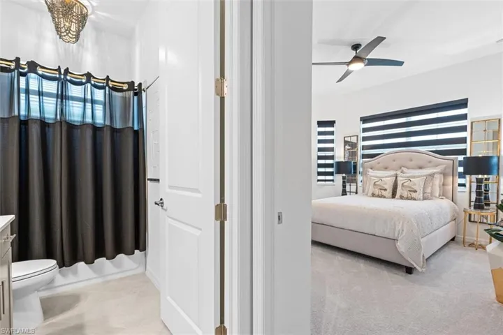 Bedroom with light colored carpet and ceiling fan