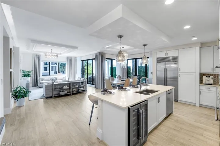Chef's Kitchen with Quartz Island - Wine Refrigeration - Great Room - Dining out to wrap around covered  lanai