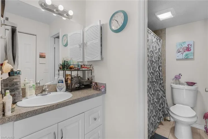Full bath with a shower with shower curtain, light tile patterned floors, vanity, and a textured ceiling