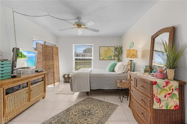 Bedroom featuring light tile patterned floors, a textured ceiling, and a ceiling fan
