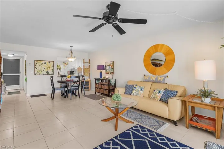 Living area featuring light tile patterned floors and ceiling fan