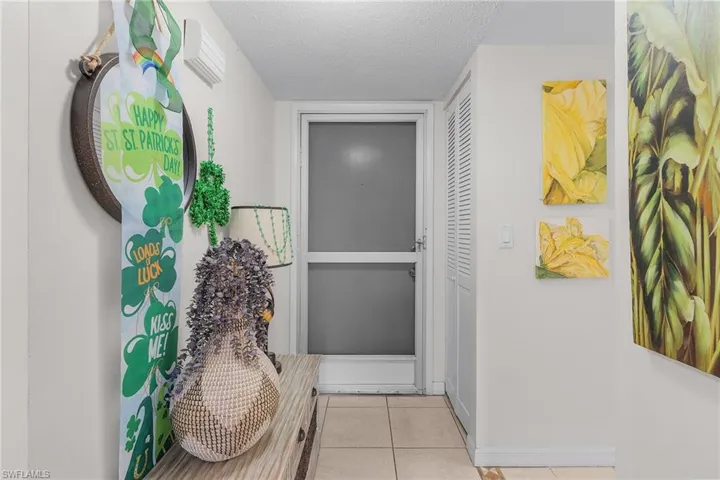 Doorway to outside featuring tile patterned flooring and a textured ceiling