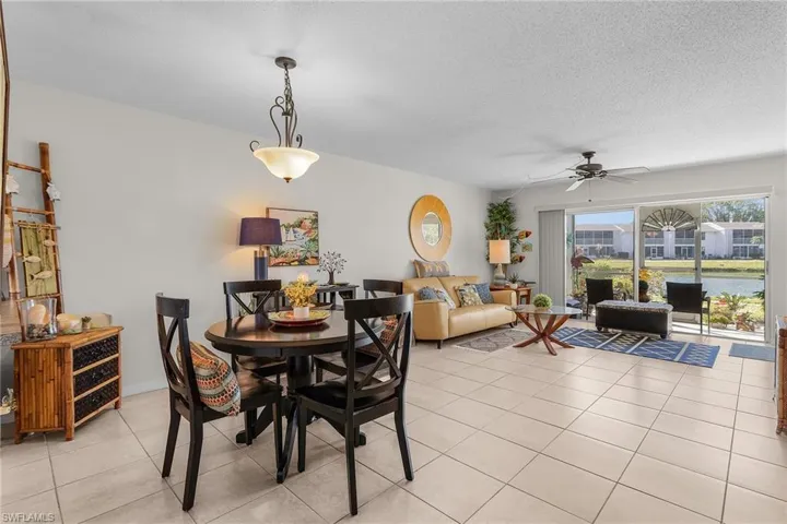 Tiled dining space with a ceiling fan and a textured ceiling