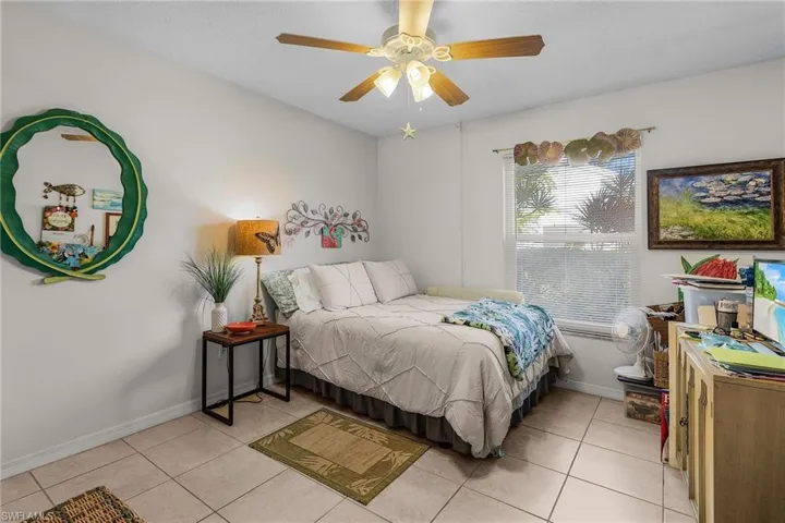 Bedroom with light tile patterned floors and ceiling fan