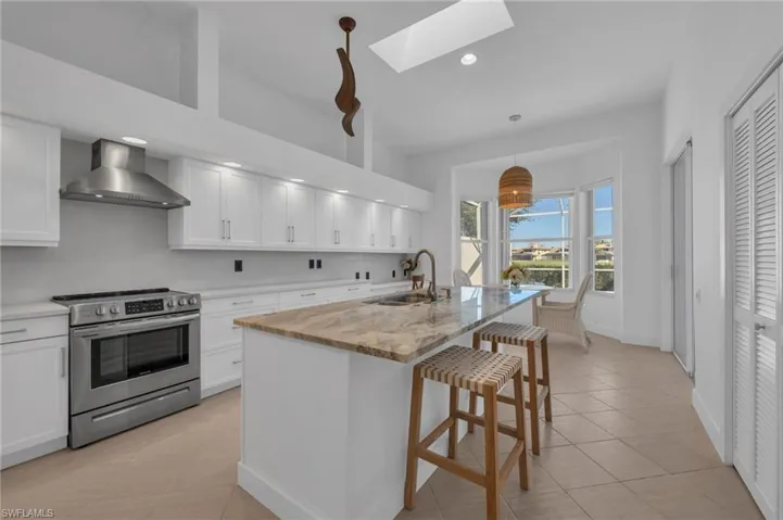 Renovated Kitchen with white cabinets, white quartz counters and earth tone quartz island counter.