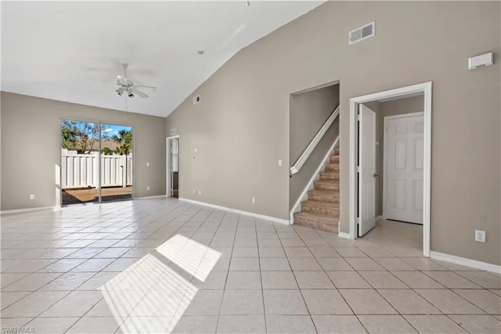 living area featuring ceiling fan and high vaulted ceiling