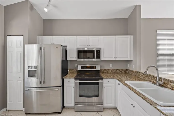 Kitchen featuring white cabinets, a healthy amount of sunlight, sink, and appliances with stainless steel finishes