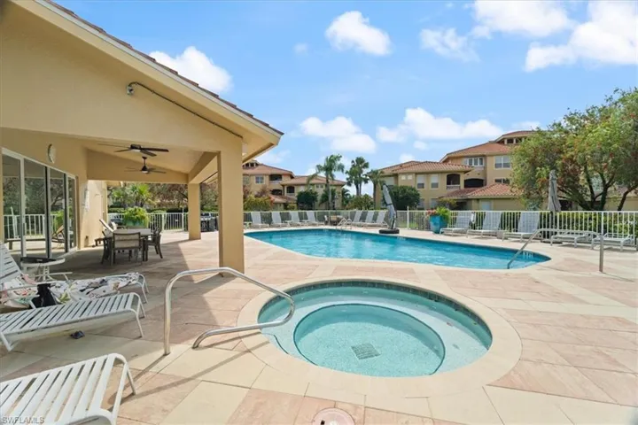 Community pool featuring ceiling fan, a community hot tub, a patio, and fence