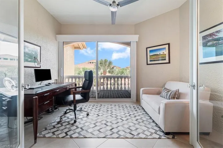 Office area featuring tile patterned flooring, ceiling fan, french doors, and a textured wall