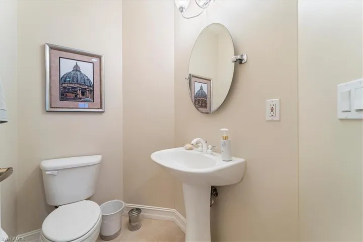 Bathroom featuring tile patterned flooring, baseboards, and toilet