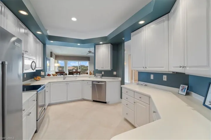 Kitchen featuring stainless steel appliances, recessed lighting, light countertops, and white cabinets