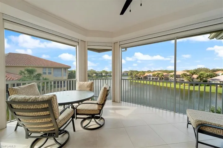 Sunroom / solarium featuring ceiling fan and a water view