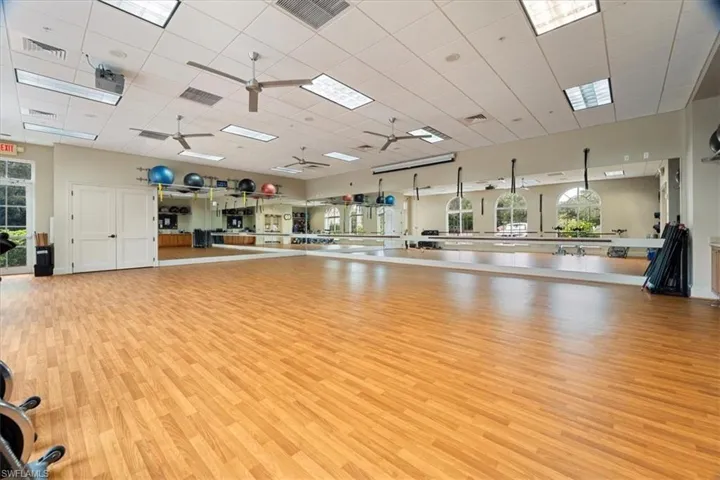 Exercise room with a drop ceiling and ceiling fan