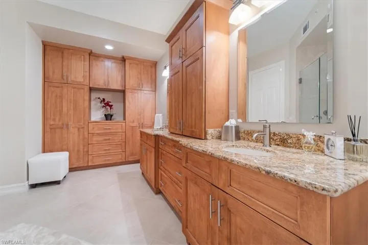 Bathroom featuring tile patterned flooring, vanity, visible vents, baseboards, and a shower stall