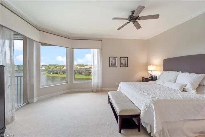 Carpeted bedroom with access to exterior, multiple windows, baseboards, and crown molding