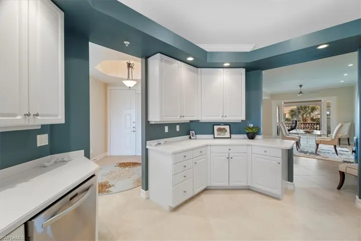 Kitchen featuring light tile patterned floors, dishwasher, light countertops, white cabinetry, and recessed lighting