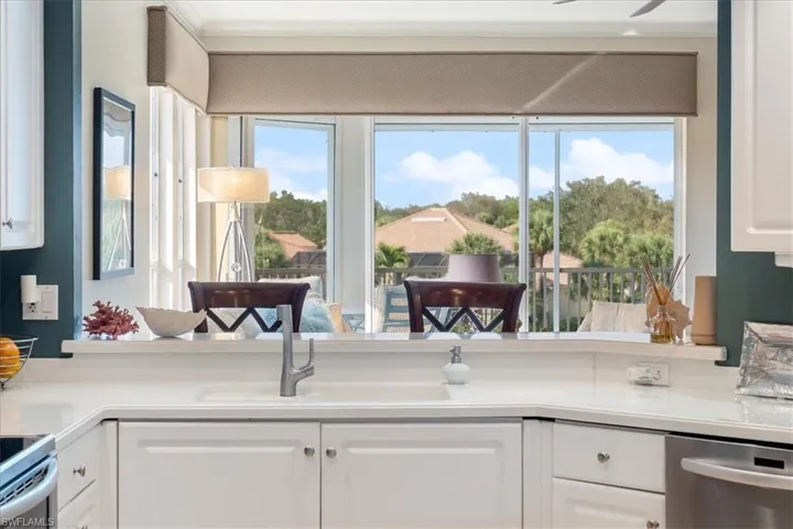 Kitchen with plenty of natural light, a sink, and white cabinets