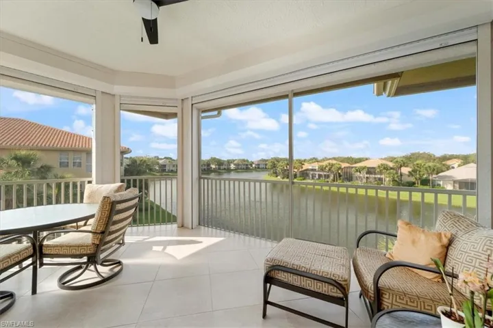 Sunroom / solarium featuring ceiling fan and a water view