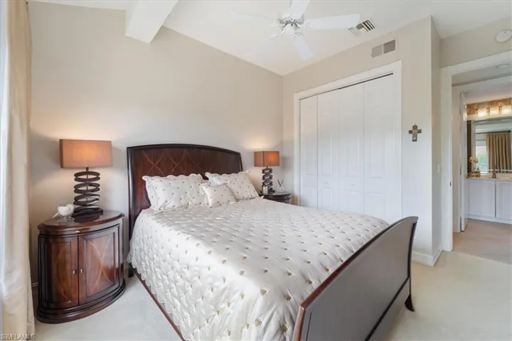 Bedroom with a closet, visible vents, and light carpet