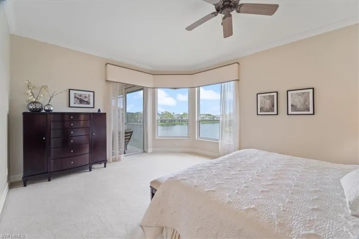 Bedroom featuring a ceiling fan, baseboards, access to exterior, carpet, and crown molding
