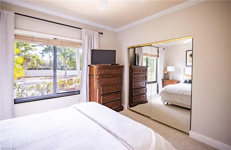 Bedroom with neutral wall tones and crown molding