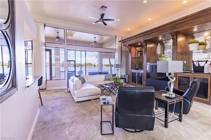 Spacious living area featuring extensive window walls, recessed lighting, and a detailed wood-finish built-in entertainment center
